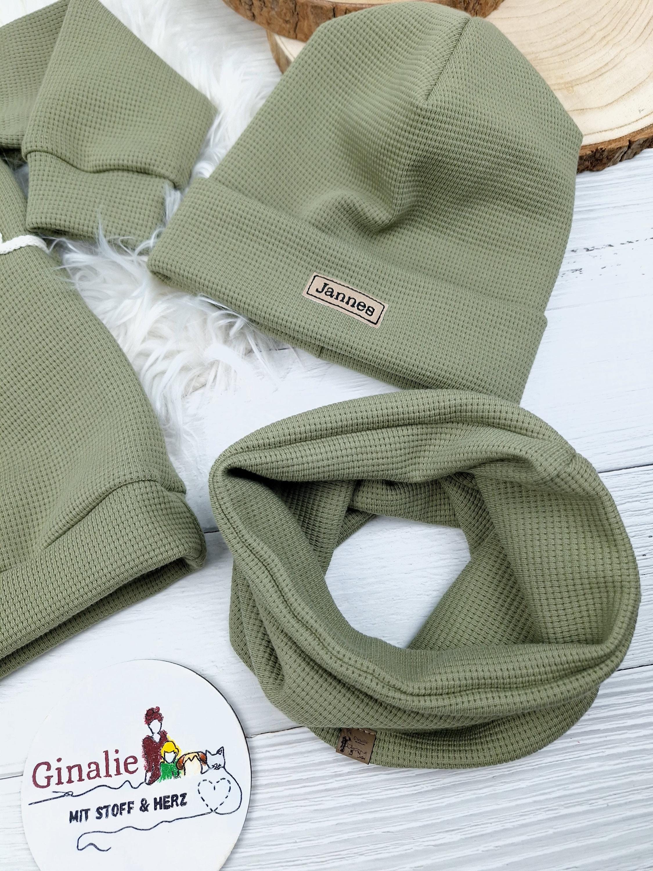 Olivfarbene Beanie mit Lederpatch mit personalisierten Namen, dazu ein passender Loop Schal