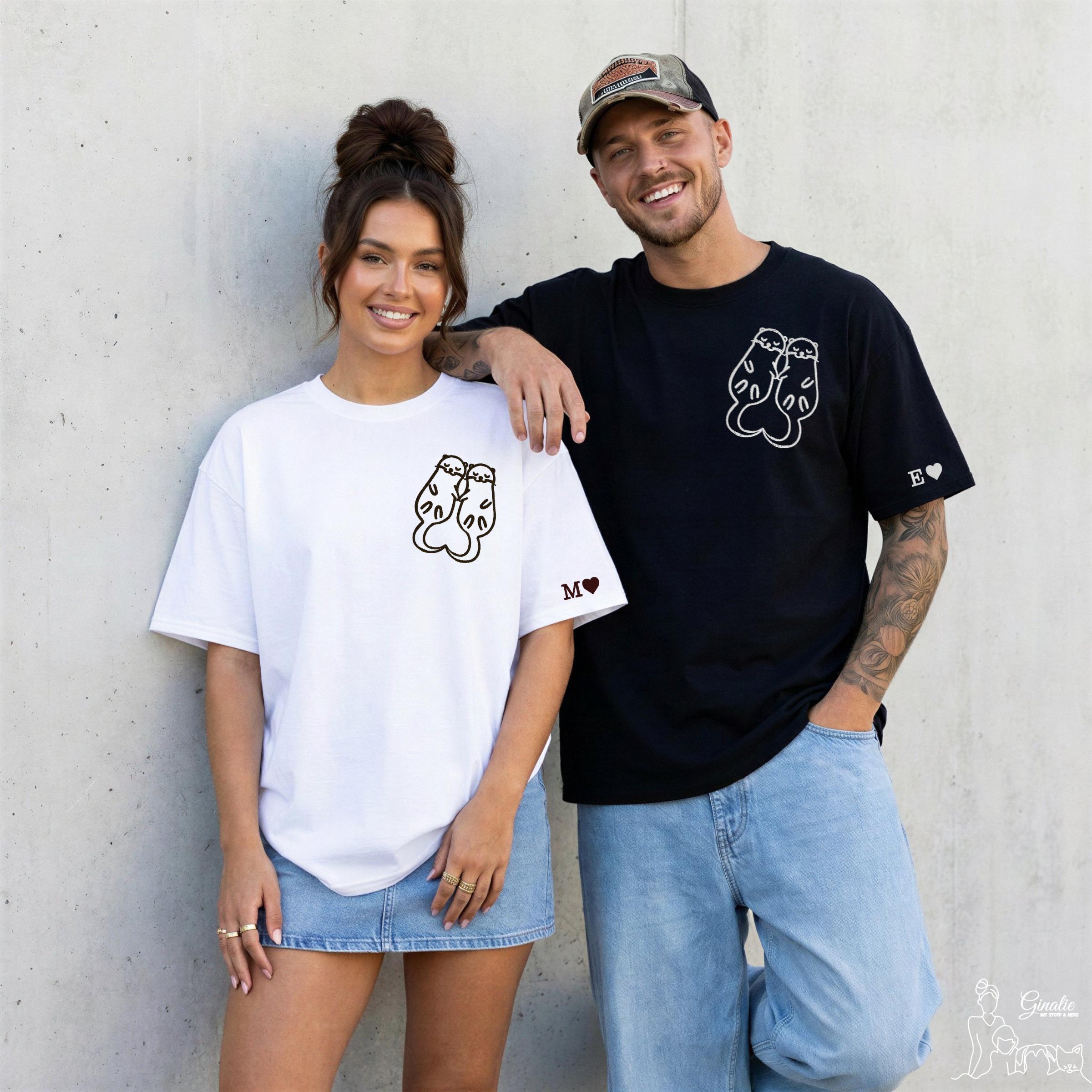 Pärchen mit Otter T-Shirts. Frau trägt ein weißes Shirt und Mann ein schwarzes.