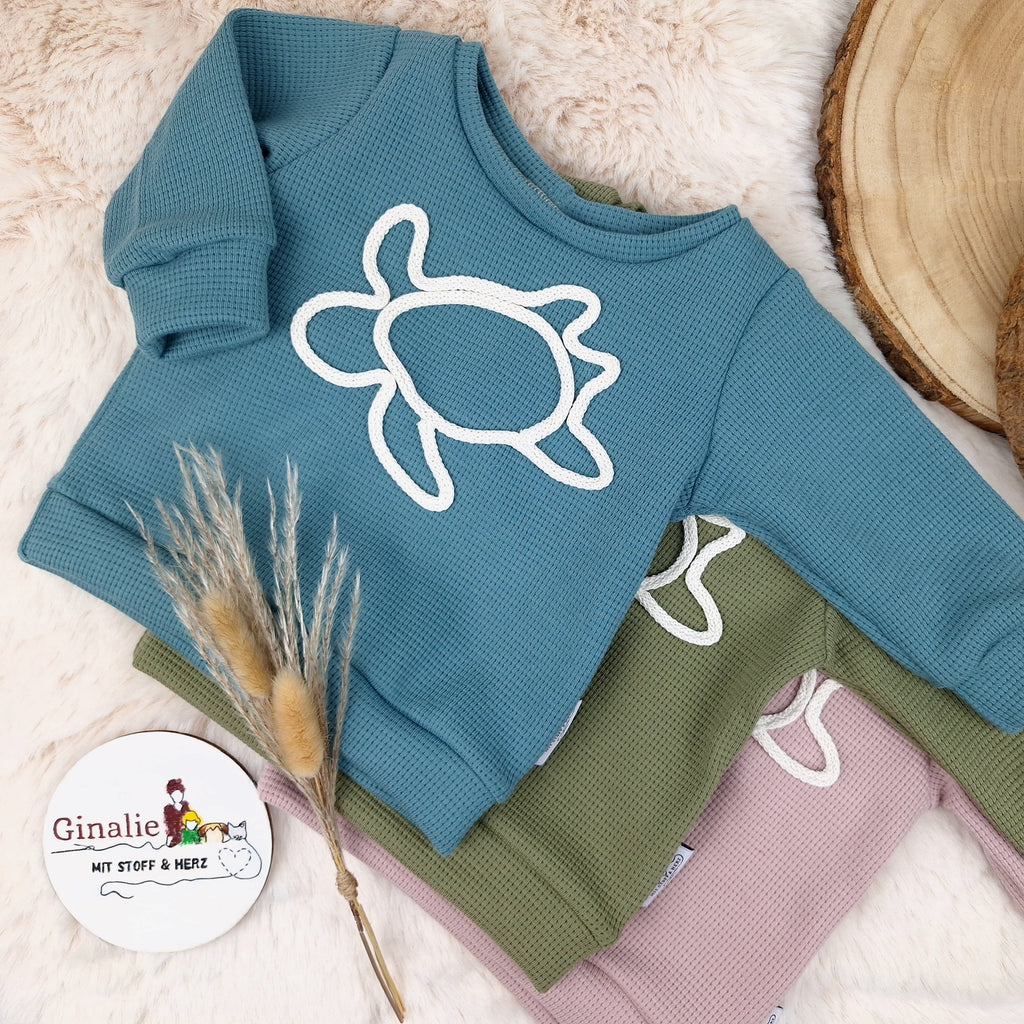 Pullover mit Schildkröte aus Kordel drauf.
